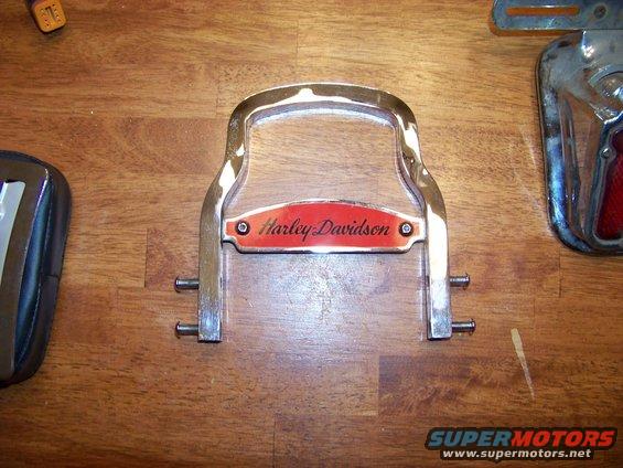 Chrome Harley-Davidson luggage rack part on wooden surface