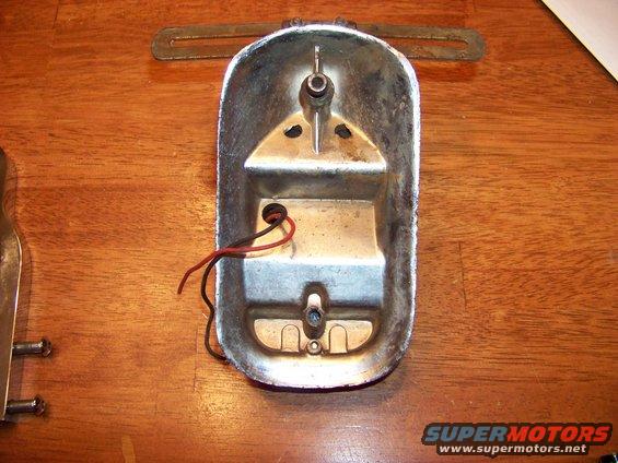 Rear view of a chrome car tail light housing with red and black wires