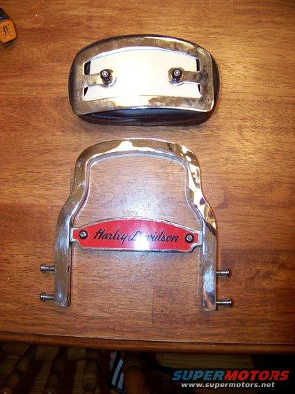 Harley-Davidson emblem and chrome part on wooden surface