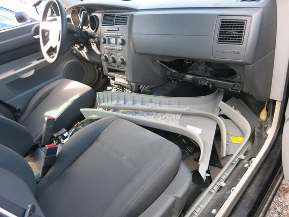 Interior of a Dodge vehicle with disassembled dashboard and seats