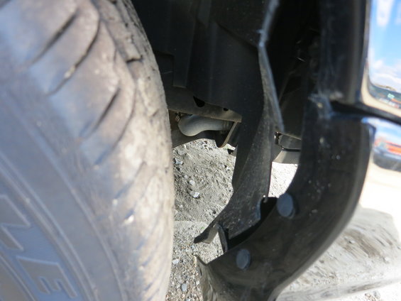 Close-up of a tire and damaged fender liner