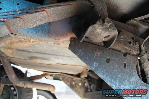 Close-up of rusty undercarriage components and exhaust pipe on a truck
