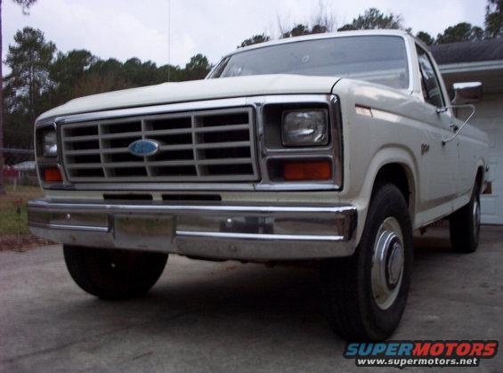 Front view of a white 1980s Ford F-Series truck with a chrome grille and bumper