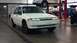 1993 Mercury Tracer - White 1993 Mercury Tracer in a service bay, with another car undergoing maintenance overhead.