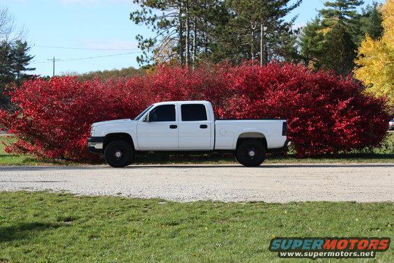 White 2006 Chevrolet Silverado 2500 crew cab pickup truck parked on a gravel road