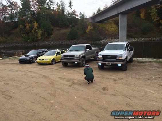 2006 Chevrolet Silverado 2500 parked with other vehicles near a river
