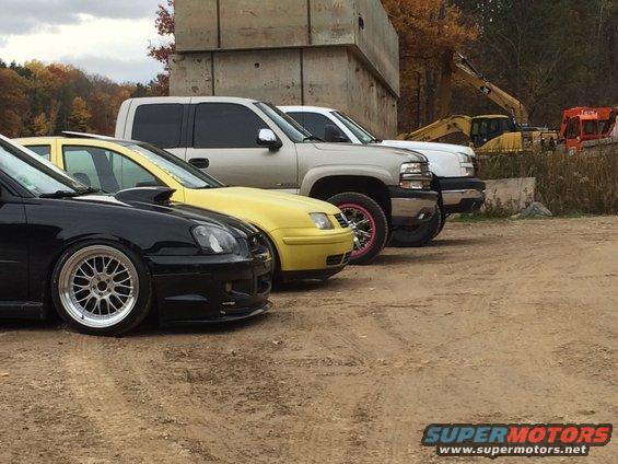 Black Subaru WRX, yellow Volkswagen Jetta, and a silver Chevrolet Silverado pickup truck parked side-by-side