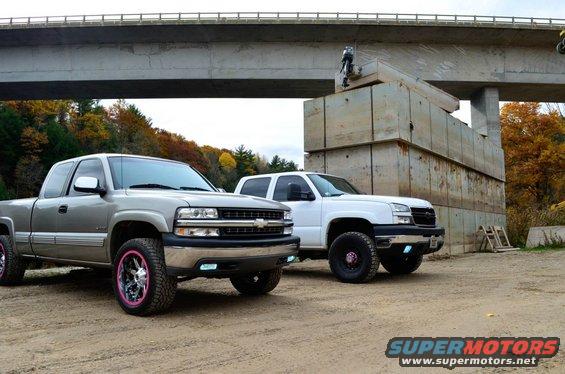 Silver Chevrolet Silverado 2500 with pink rims parked on dirt, front 3/4 view