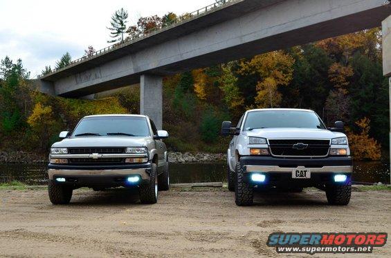Front view of two 2006 Chevrolet Silverado 2500 trucks parked under a bridge