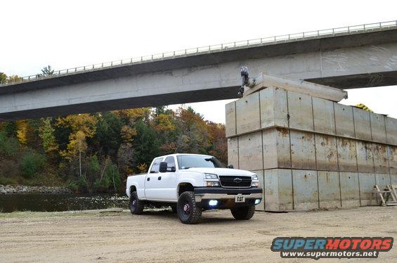White 2006 Chevrolet Silverado 2500 parked near a bridge construction site