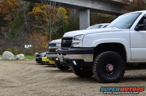 White 2006 Chevrolet Silverado 2500 pickup truck front 3/4 view with other vehicles behind