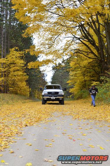 White 2006 Chevrolet Silverado 2500 front view on a road covered in autumn leaves