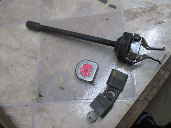 Bearing puller, tape measure, and two padlocks on tiled floor