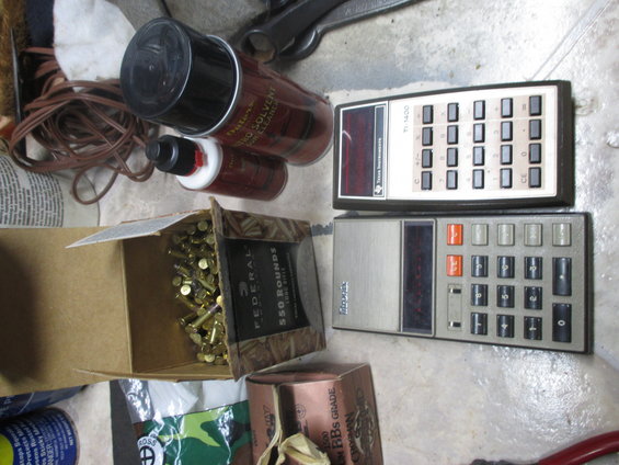 Two calculators, spray cans, and ammunition on a floor