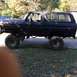1979 Ford Bronco - Side profile of a modified Ford Bronco, likely from the late 1970s, with significant suspension lift and oversized tires.