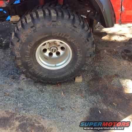 Red vehicle fender and large off-road tire with silver rim, close-up