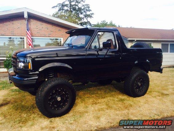 1992 Ford Bronco, black, lifted, with aftermarket wheels and spare tire on back