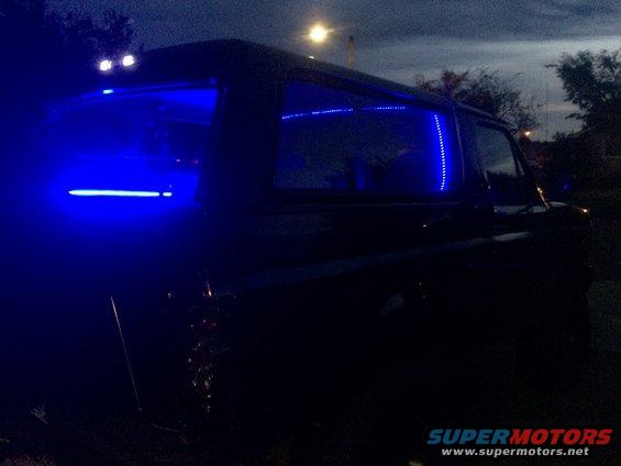 Black 1992 Ford Bronco with blue LED interior lighting, viewed from the rear passenger side