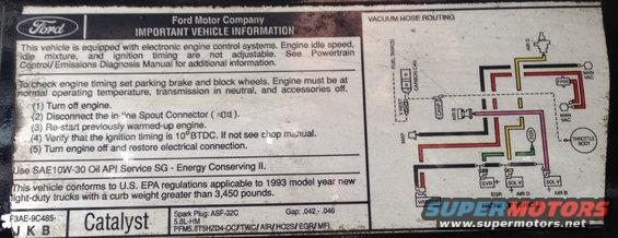 Vehicle information sticker with vacuum hose routing diagram and text about emissions