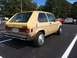 1983 Volkswagen Rabbit - Rear view of a tan 1983 Volkswagen Rabbit hatchback with aftermarket hubcaps.