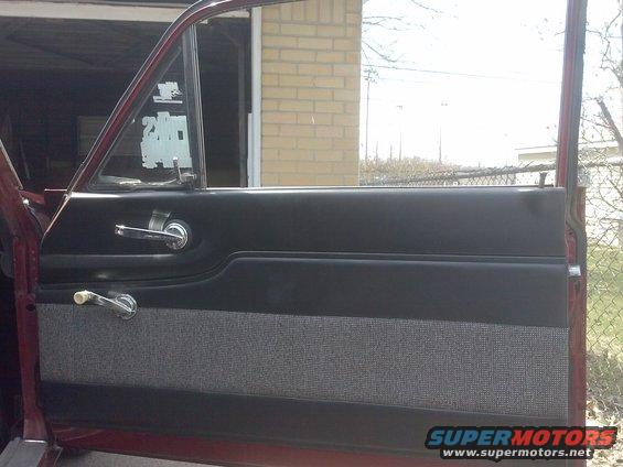 Interior door panel with chrome handles and window crank. Maroon exterior visible