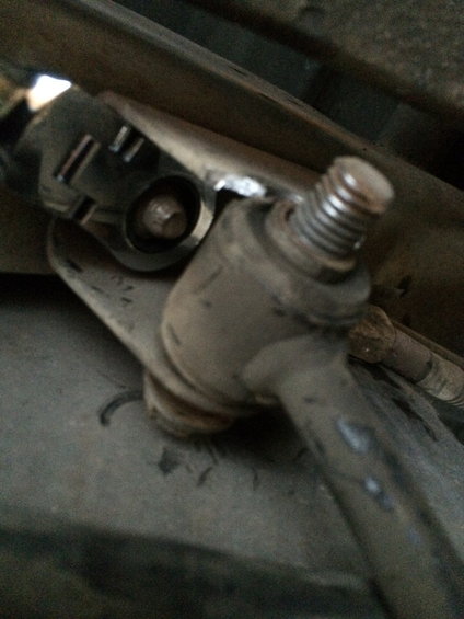 Close-up of a sway bar end link connection with a bolt and threaded rod