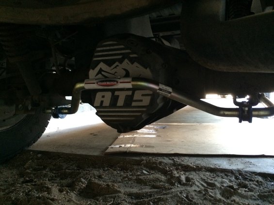 Underneath a vehicle showing the rear differential cover with ATS branding and a sway bar installed
