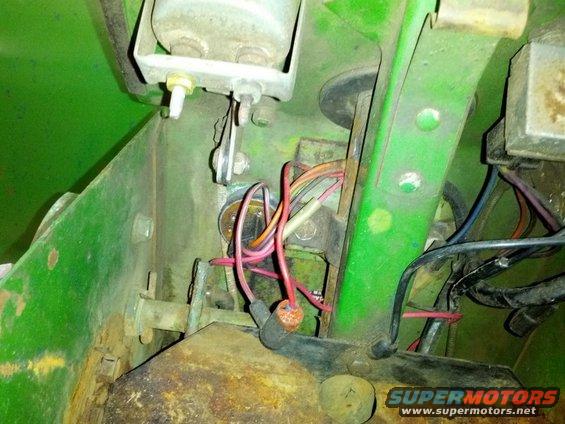 Green metal structure with exposed red and black wires, connectors, and bolts. A "SUPERMOTORS.NET" watermark is visible