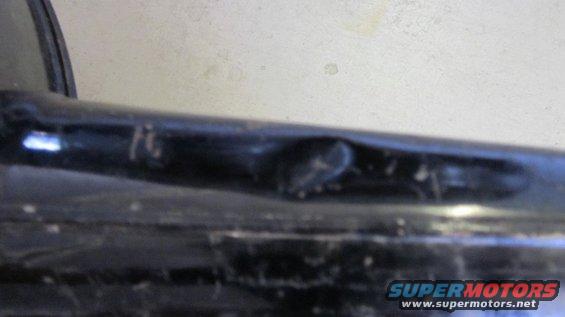 Bent black metal pipe with a dent and some scratches