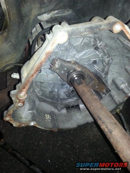 Close-up of a transmission bell housing with a clutch fork. There's a 'V8' marking on the housing