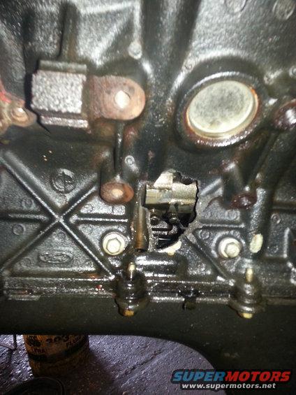 Engine block with a large hole in the side, showing internal components