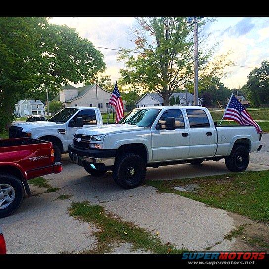 White 2006 Chevrolet Silverado 2500 with American flags on the back