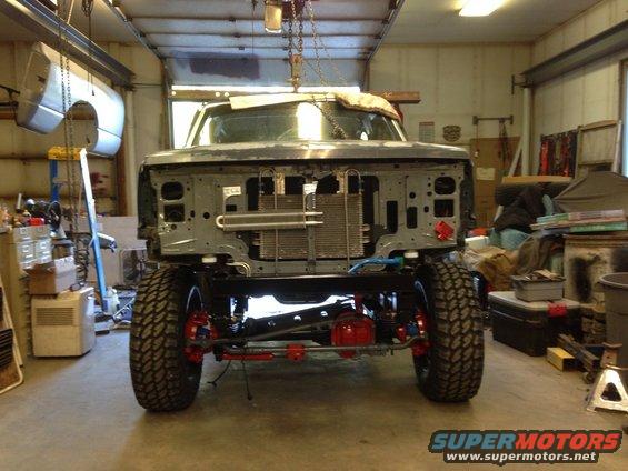 1993 Ford Bronco front end with grille removed, showing radiator and suspension components, in a garage
