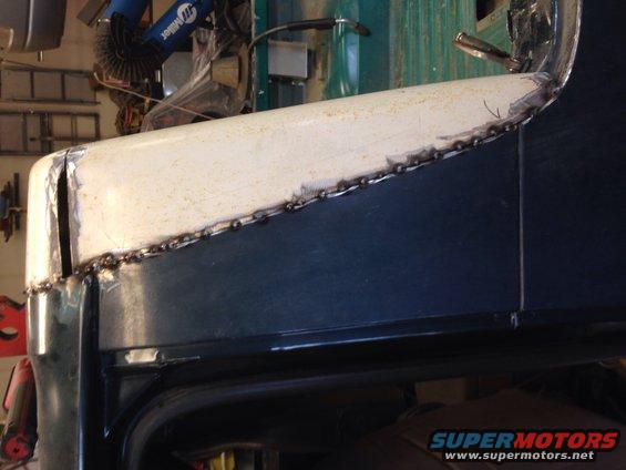 Welded body panel repair on a dark blue vehicle