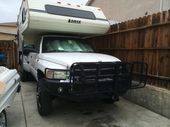 1997 Dodge 3500 truck with a Lance camper shell and a brush guard