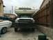 1997 Dodge 3500 - A white Dodge Ram truck with a camper shell is parked in a driveway next to a boat and a white car.