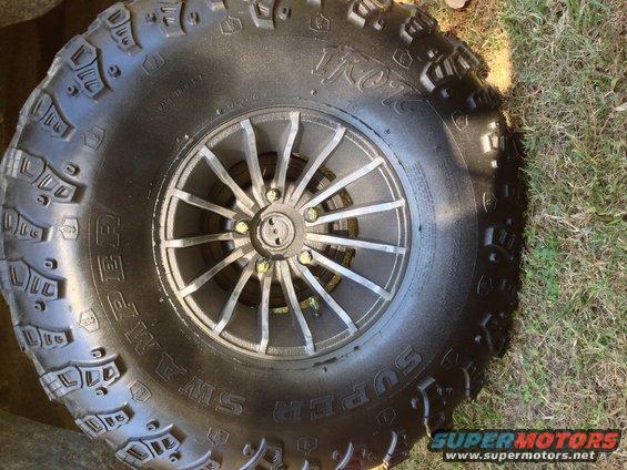 Close-up of a Super Swamper tire on a multi-spoke wheel