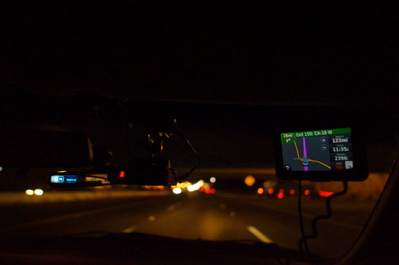 Dashboard view at night showing GPS navigation and radar detector