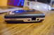 2003 Ford Taurus - Escort radar detector shown on a wooden table, with a laptop in the background.