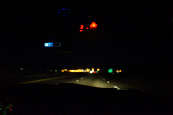 Interior view at night, showing dashboard lights and road ahead
