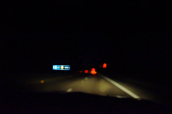 Dashboard display at night showing 60 mph and R for reverse