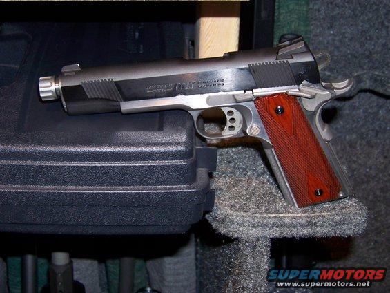 Colt 1911 pistol with wood grips on a gun case