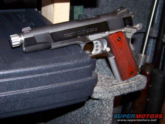 Colt Government Automatic .45 pistol with wooden grips and threaded barrel