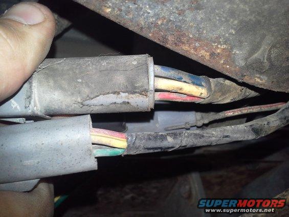 Close-up of two gray wiring harness connectors with exposed wires in red, yellow, blue, and green