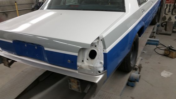 1991 Ford Crown Victoria LTD rear end, white and blue two-tone paint, missing taillight, on repair lift