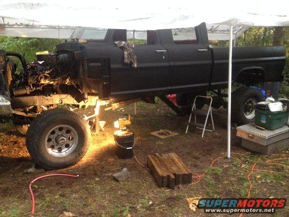 Black 1971 Ford F-250 crew cab pickup truck with engine removed, undergoing repairs