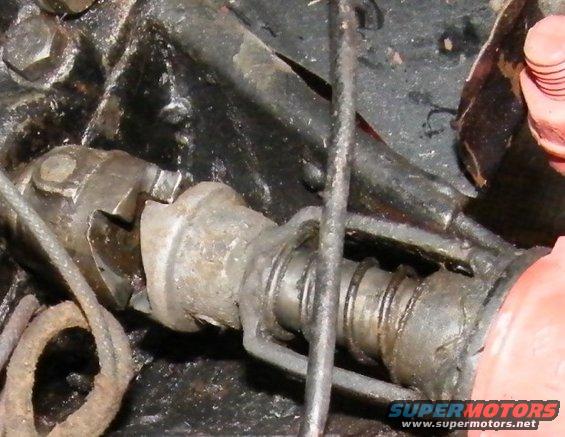 Close-up of a mechanical linkage with cables and a spring