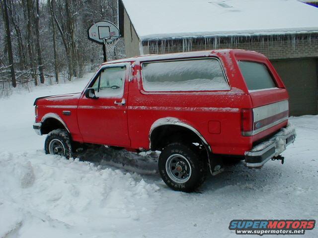 Red 1990 Ford Bronco in snow, 3q-front view