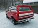 1990 Ford Bronco - Red 1990 Ford Bronco covered in snow with a basketball hoop in the background.