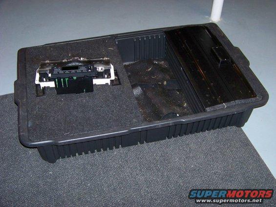 Center console storage bin with radio unit removed, showing internal wiring connectors